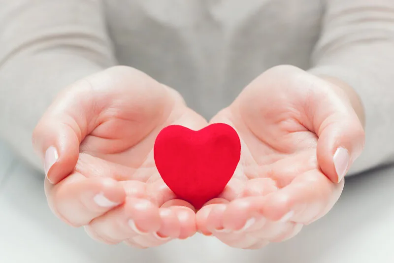 Woman holding a heart shape representing women's heart health